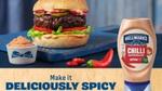 Image of a Hellmann’s chilli- flavoured mayo squeeze bottle in front of a fully loaded burger.