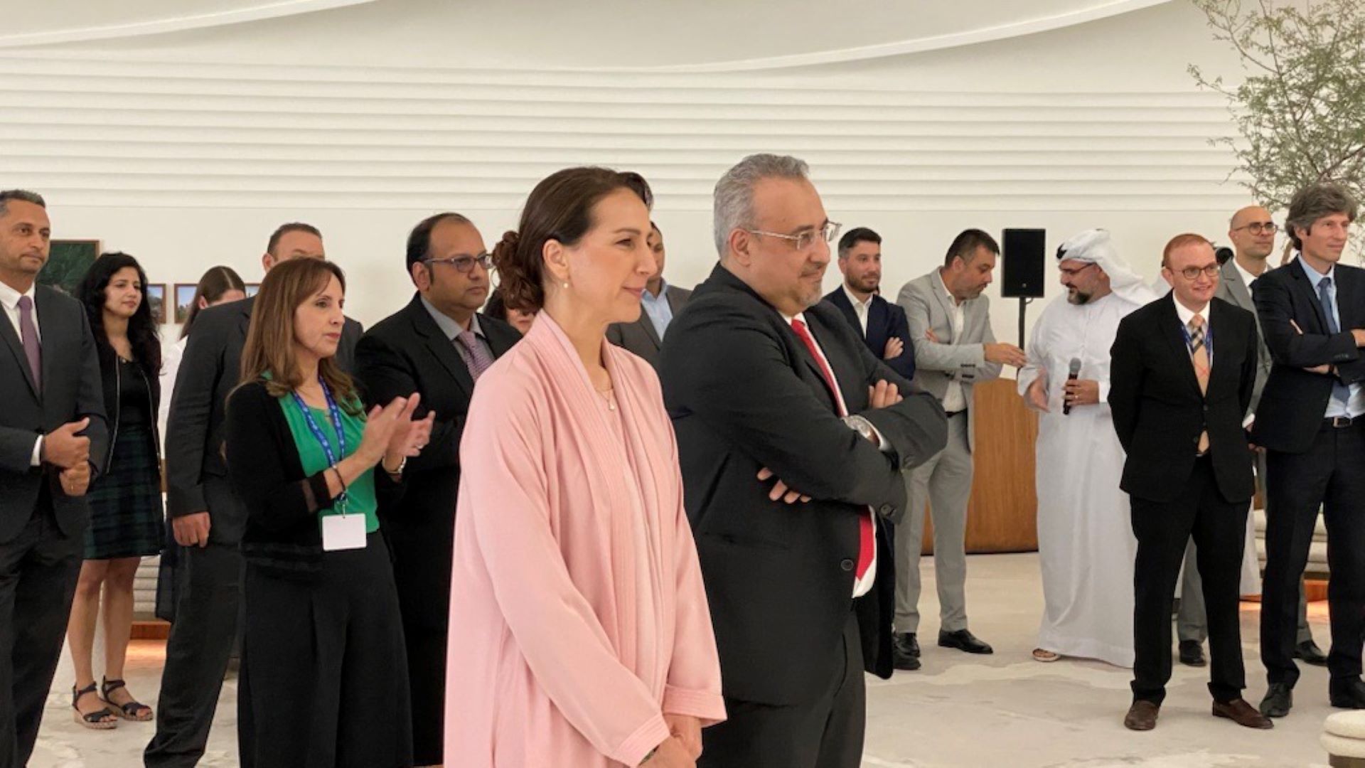 Minister of Climate Change and Environment (female) and Head of Unilever (male) standing and listening to speaker give a speech.