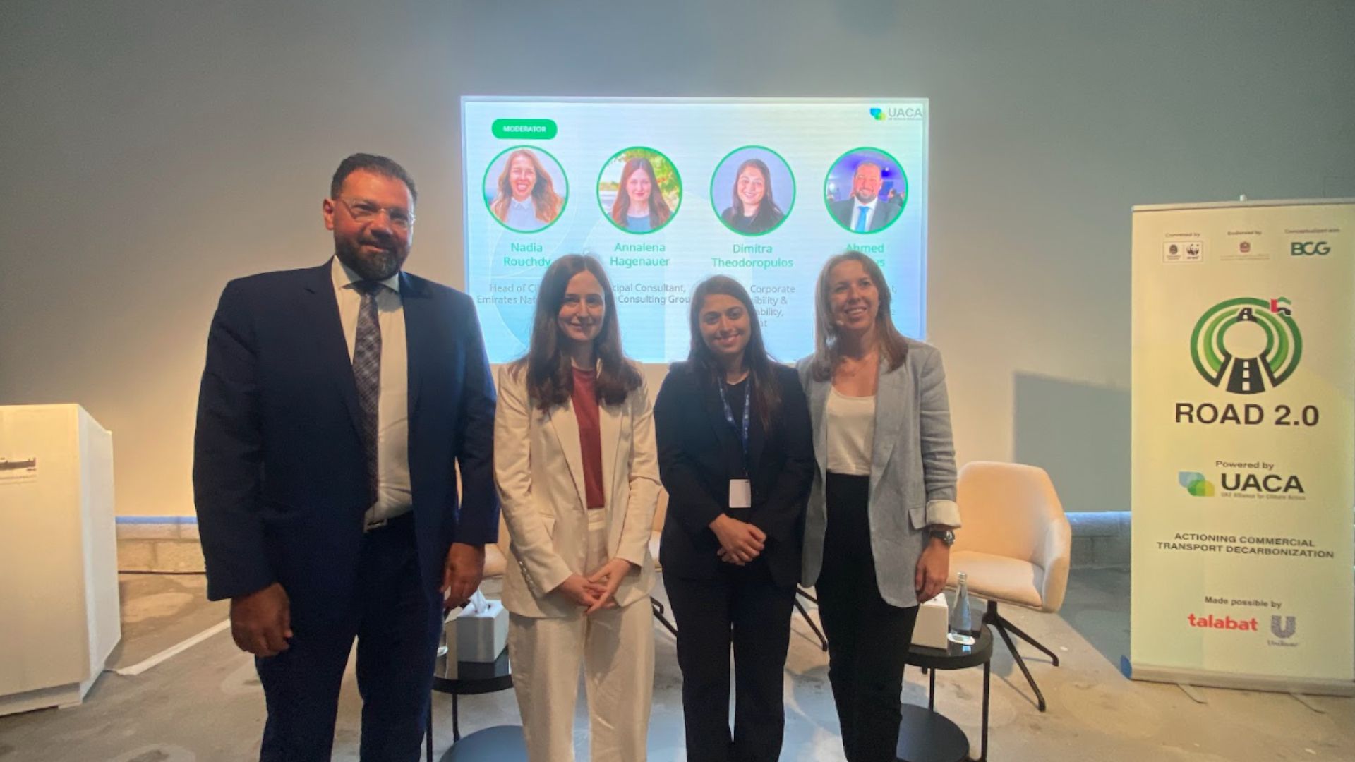 Group of panelists sitting on stage, discussing their pledge to sustainable logistics.