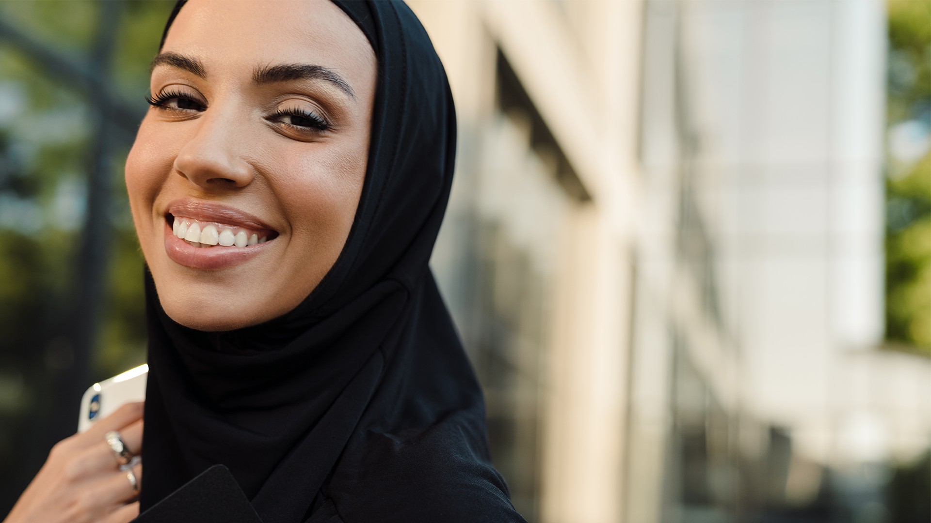 Woman wearing a hijab holding a phone