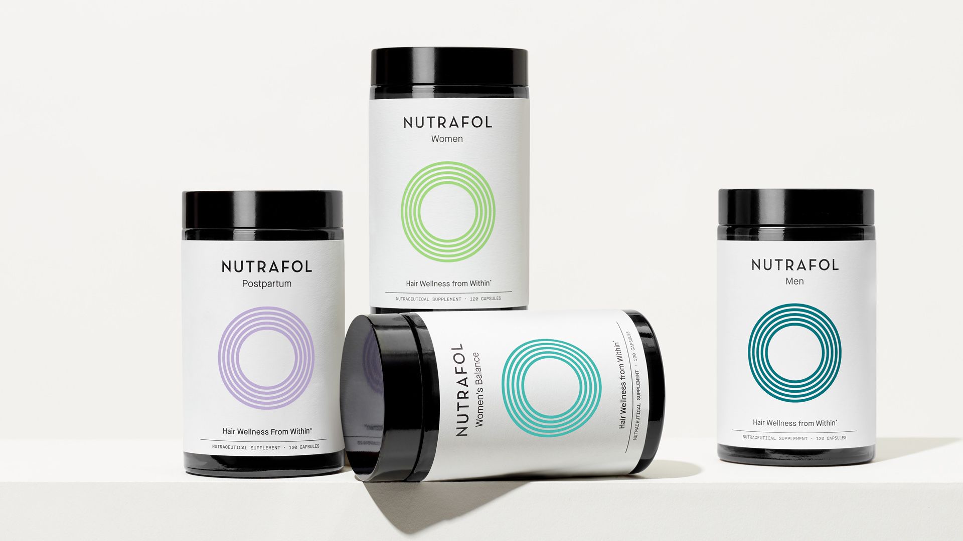 Four jars of Nutrafol products which are designed to help hair health for women and men at various stages in their lives.