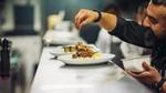 Chef adding final touches to plate of food