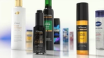A close-up display of various hair and skincare products arranged on a reflective surface, including Dove Bond Strength conditioner, TRESemmé Silk Press serum, TRESemmé Lamellar Gloss finishing oil, and other branded items in the background.