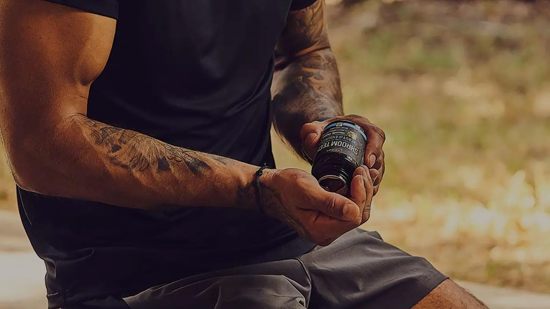 Muscular man taking Onnit’s Shroom Tech Sport supplements, designed to help with cellular energy and cardiovascular endurance.