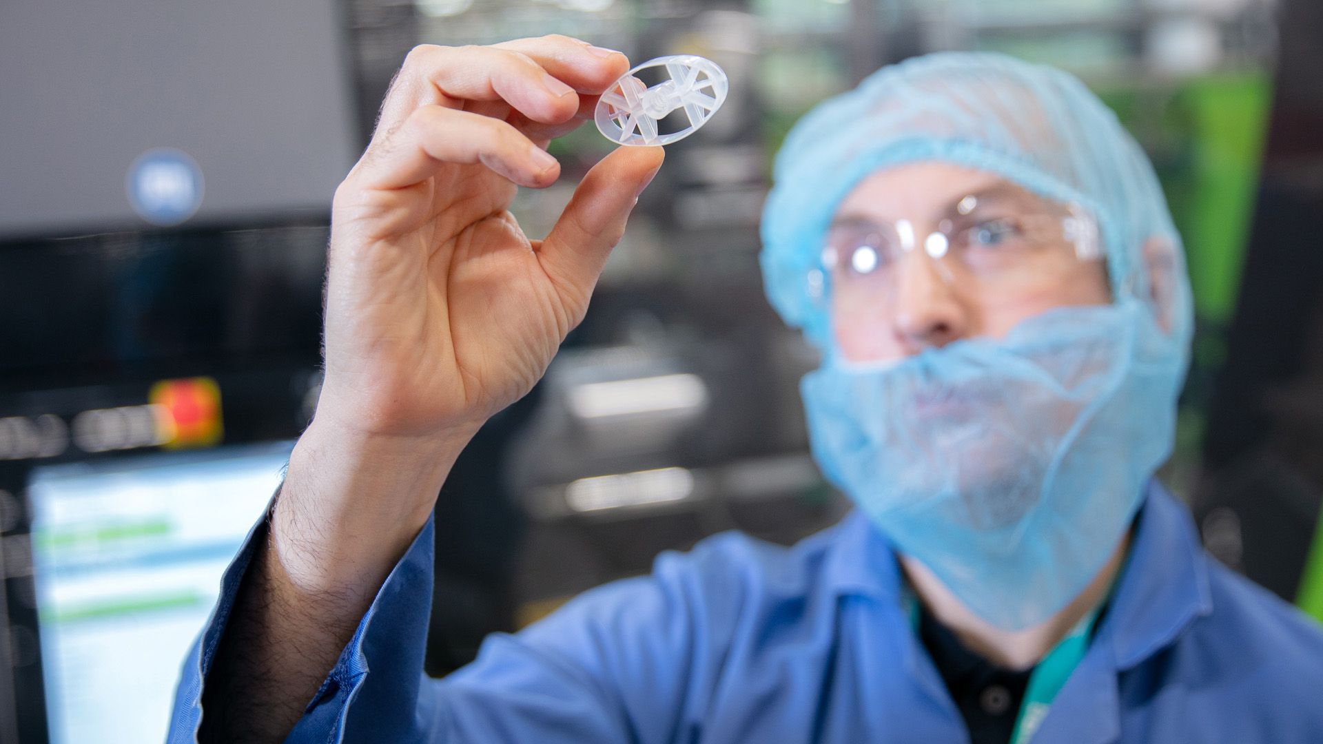Unilever scientist inspecting a deodorant packaging component made from recycled plastic