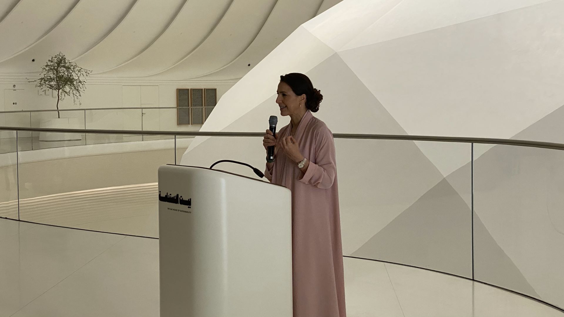 Minister of Climate Change and Environment (female) standing at a podium giving a speech.