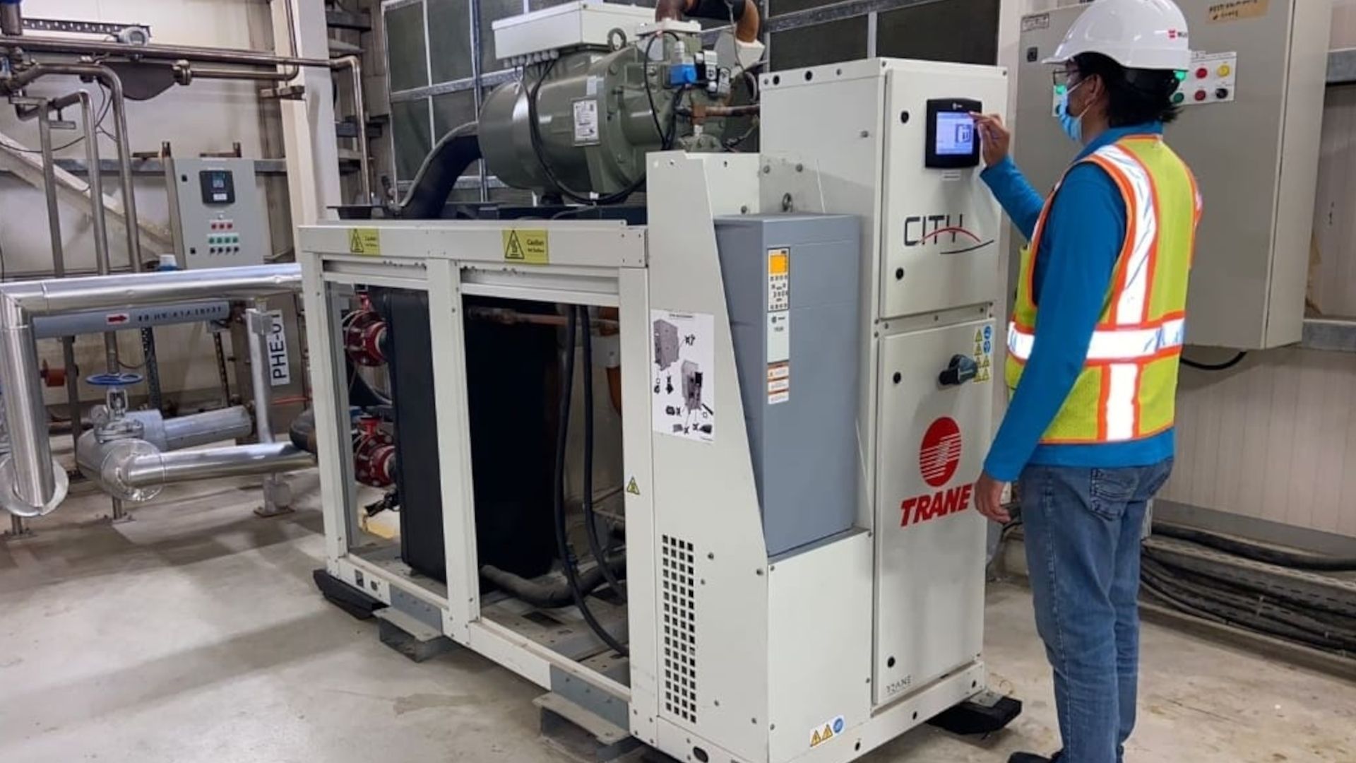 A factory worker programmes a heat pump in our Personal Care factory in Dubai, India.