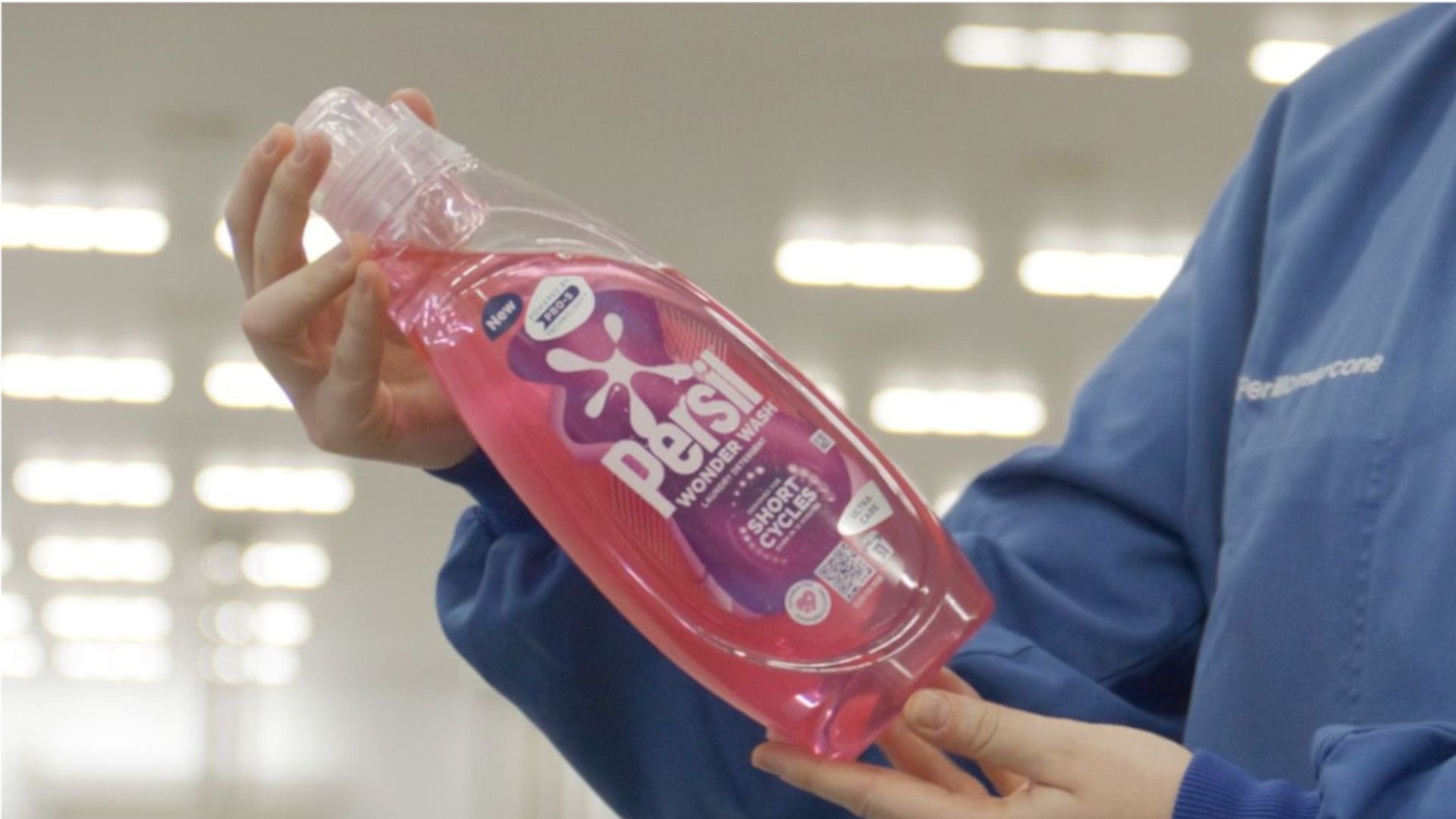 Unilever scientist inspecting Wonder Wash bottle made from recycled plastic.