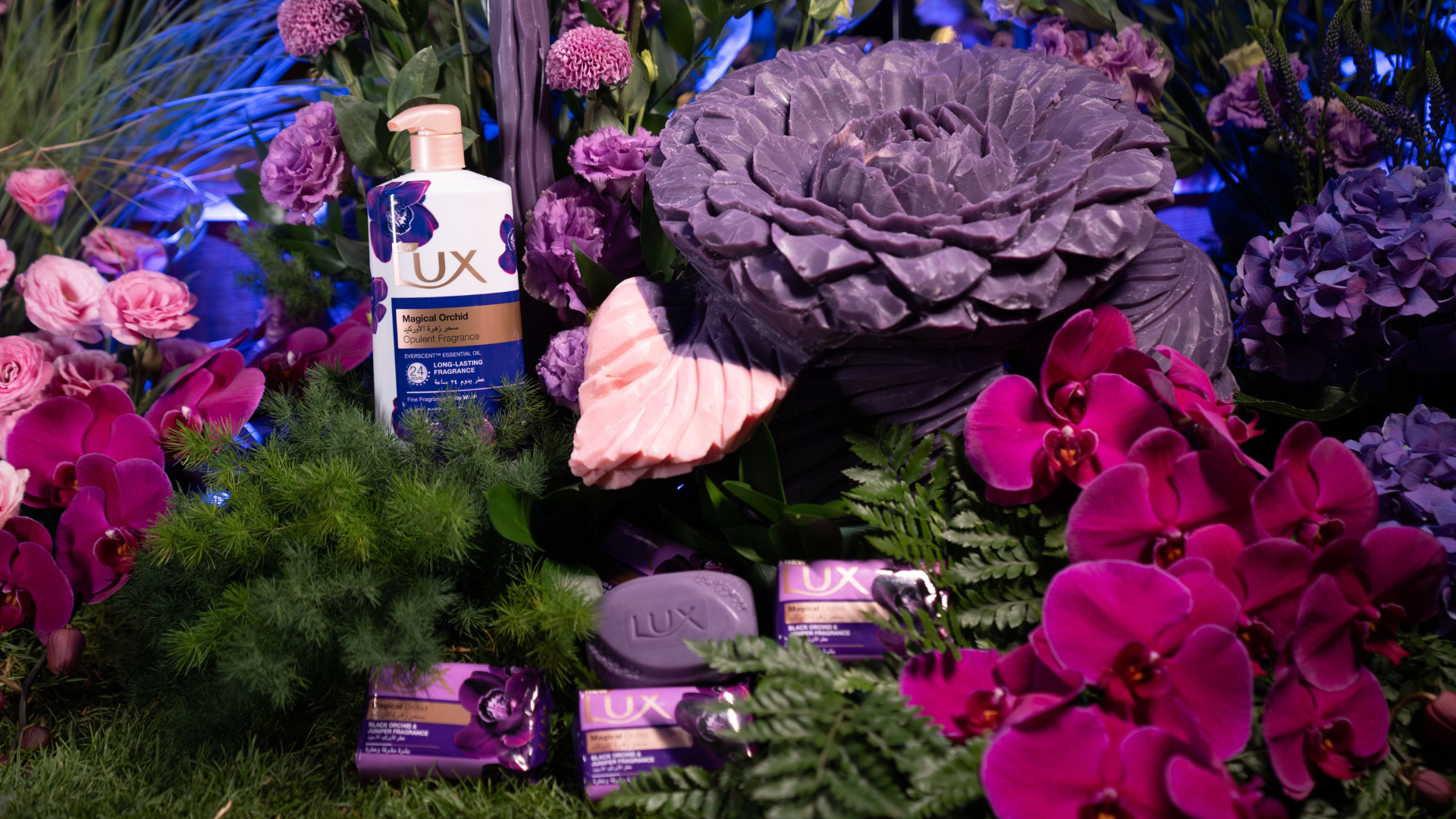 LUX bottle and bar soap on the surface of luscious flower and plant